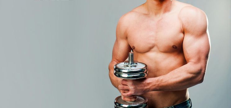 Body muscular man use his dumbbell to exercise with copy space