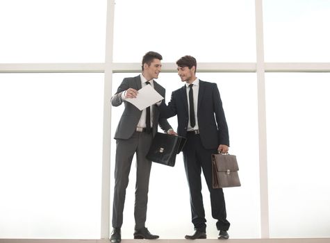 business people with leather briefcases standing near the office window.photo with copy space