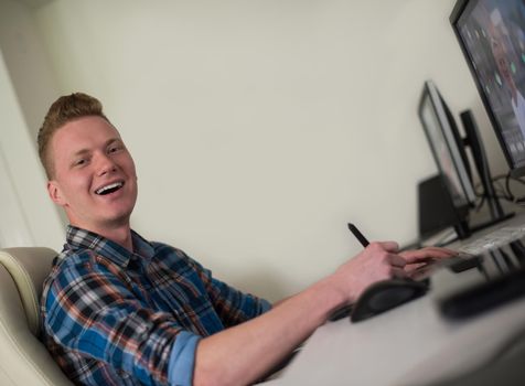 Young graphic designer working on a digital tablet and a computer