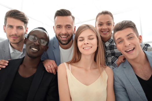 a group of young designers are sitting in the office and looking at the camera