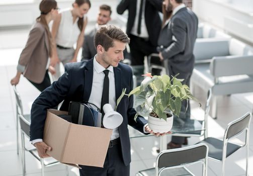 young employee with personal things standing in the office.the concept of employment