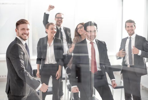 triumphant business team standing in the conference room. winning concept