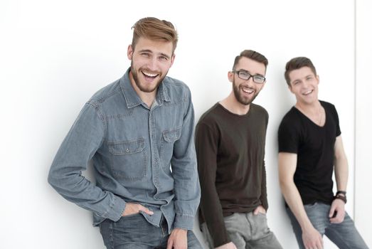 company of guys standing against a white wall