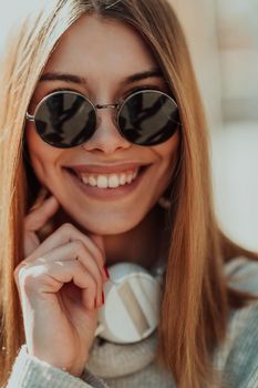 a woman in sunglasses enjoys a walk in the city while listening to music on her headphones