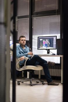 creative worker, photo editor working on graphic tablet at his desktop computer at small startup office