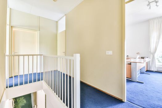 A room with a staircase leading down and a blue floor