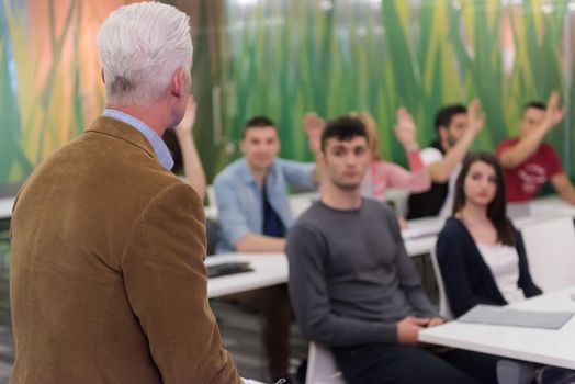 group of students study with professor in modern school classroom