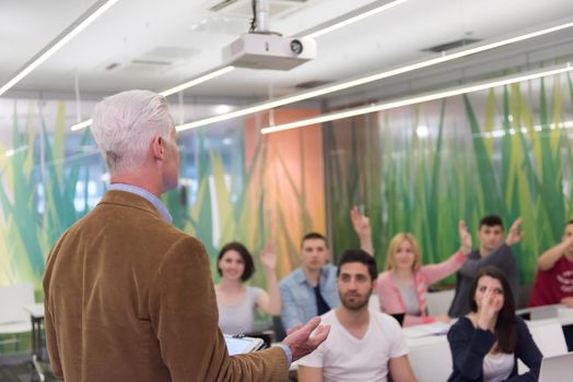 group of students study with professor in modern school classroom