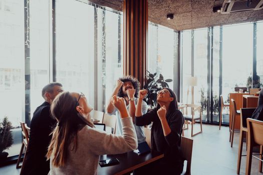 group of businessmen with their hands up celebrate successful business