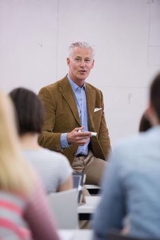 group of students study with professor in modern school classroom