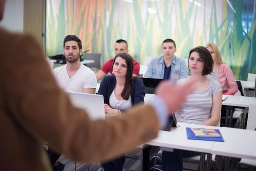 group of students study with professor in modern school classroom