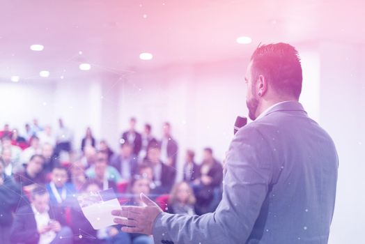 rear view of young successful businessman at business conference room with public giving presentations. Audience at the conference hall. Entrepreneurship club