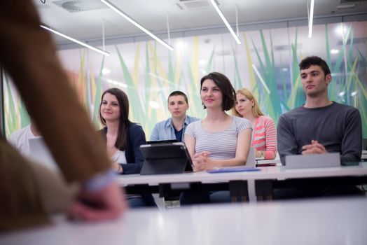 group of students study with professor in modern school classroom