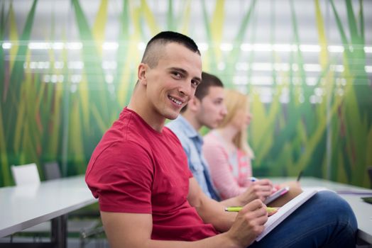 male student taking notes in classroom. business education concept, casual young businessman on seminar training