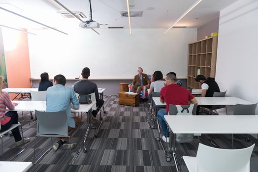 group of students study with professor in modern school classroom