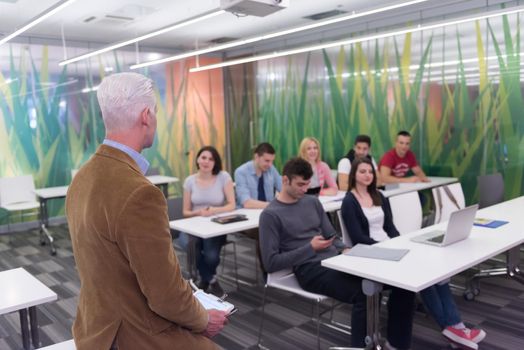 group of students study with professor in modern school classroom