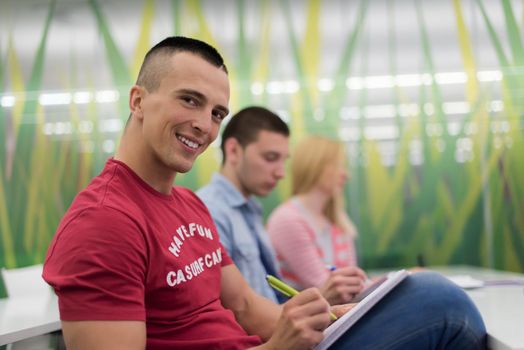 male student taking notes in classroom. business education concept, casual young businessman on seminar training