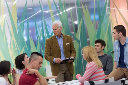 group of students study with professor in modern school classroom