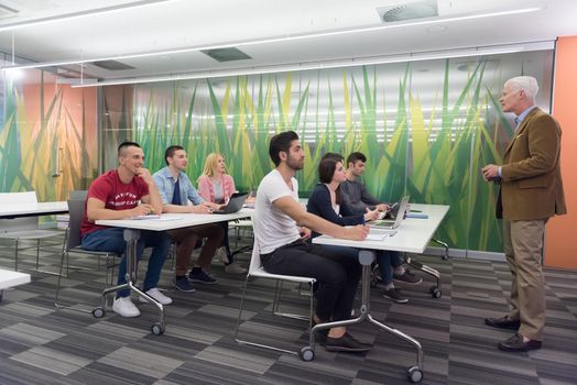 group of students study with professor in modern school classroom