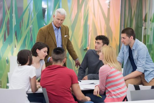 group of students study with professor in modern school classroom