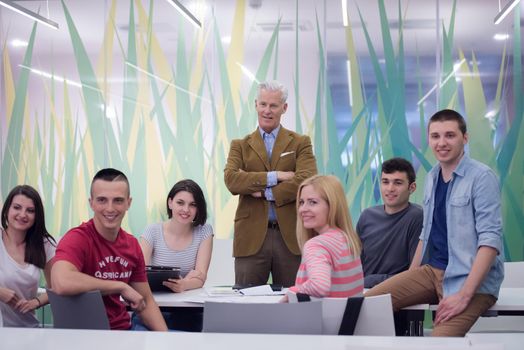 portrait of confident teacher,  students group in background