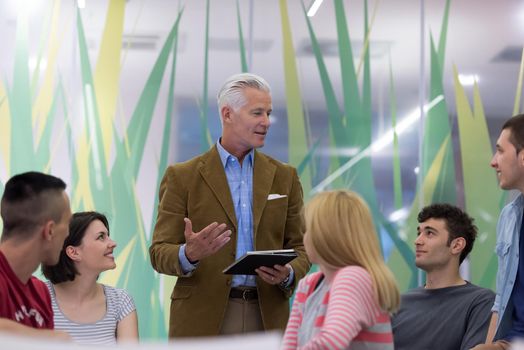 group of students study with professor in modern school classroom