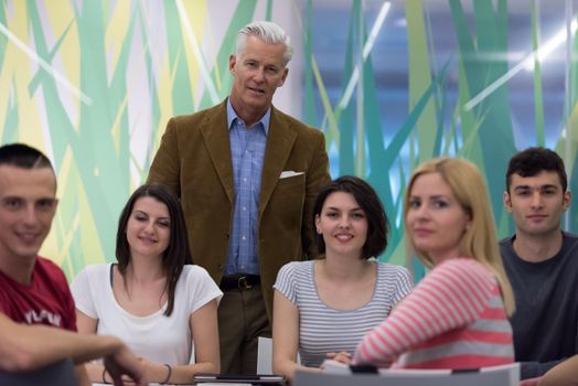 portrait of confident teacher,  students group in background