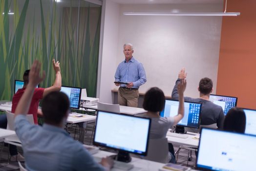 handsome mature teacher and students in computer lab classroom