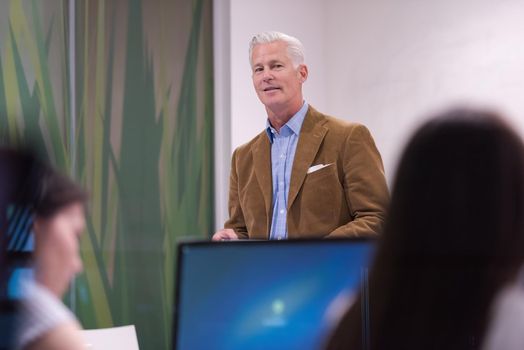 handsome mature teacher and students in computer lab classroom