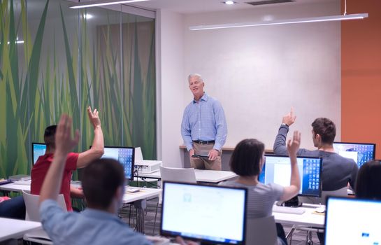 handsome mature teacher and students in computer lab classroom