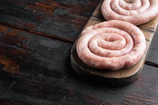 Raw spiral sausage set, on old dark wooden table background , with space for text copyspace