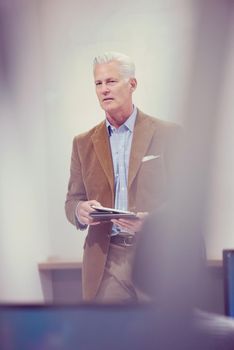 handsome mature teacher and students in computer lab classroom