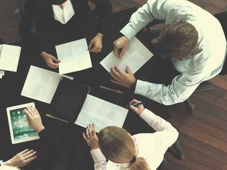 top view of  business people group on meeting, working in modern bright office indoor with tablet computer