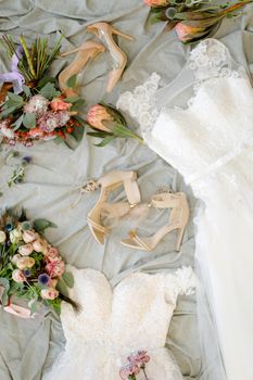 Stylish bridal shoes and flowers. Concept of fiancee wear and wedding photo session.