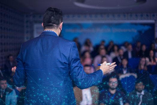 rear view of young successful businessman at business conference room with public giving presentations. Audience at the conference hall. Entrepreneurship club