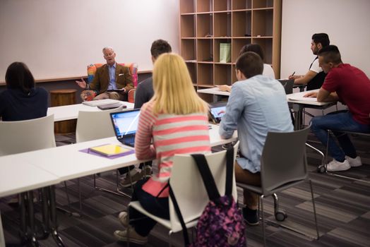 group of students study with professor in modern school classroom