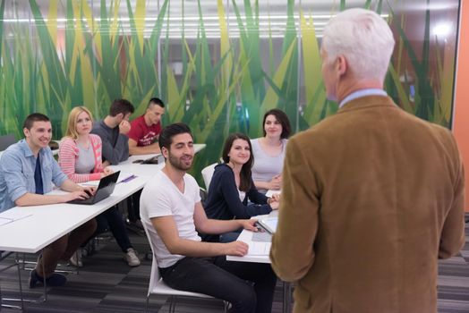 group of students study with professor in modern school classroom