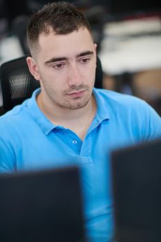 casual business man working on desktop computer in modern open plan startup office interior