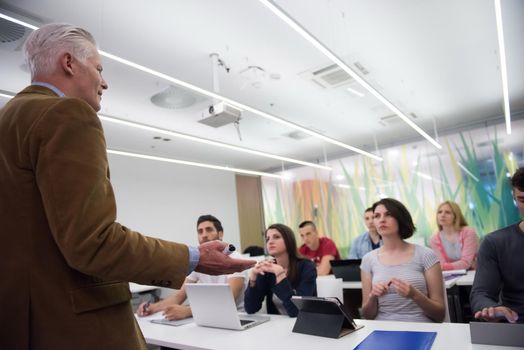 group of students study with professor in modern school classroom