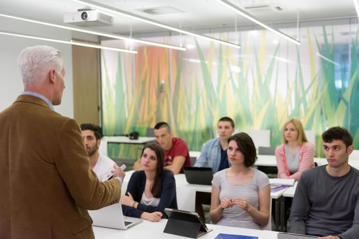 group of students study with professor in modern school classroom