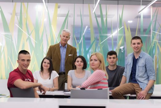 portrait of confident teacher,  students group in background