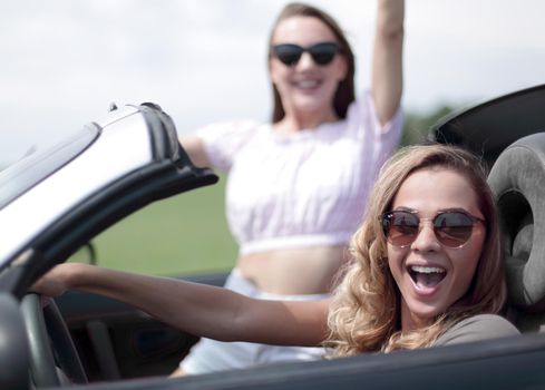 close up.two girlfriends traveling in a convertible car . fashionable lifestyle