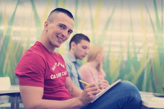 male student taking notes in classroom. business education concept, casual young businessman on seminar training