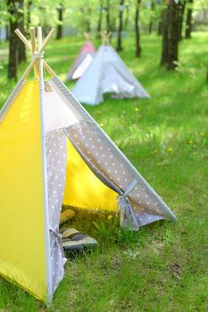 Yellow and blue tents in park. Concept of summer vacations.