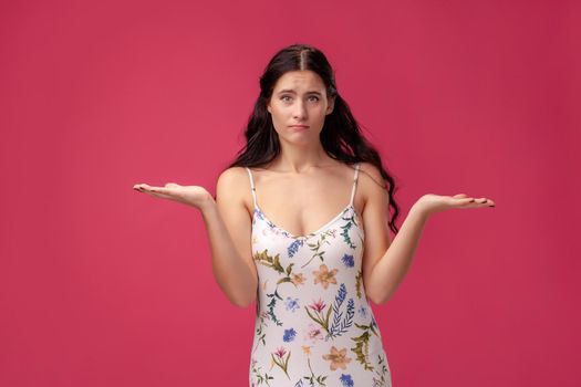 Beautiful, sweet, young girl spreads her arms on the pink background