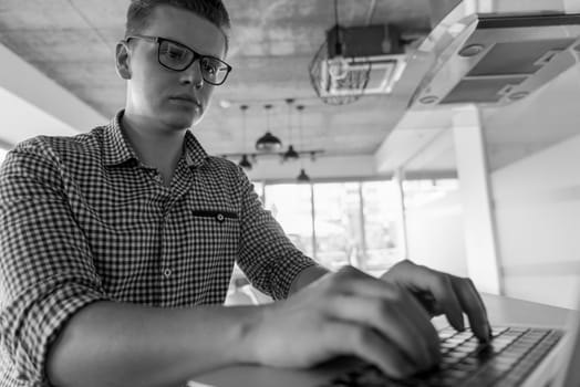 young businessman with glasses at  startup business office space working on modern  laptop  computer