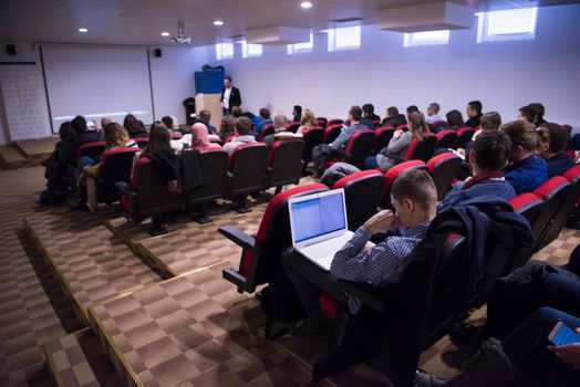 young successful businessman at business conference room with public giving presentations. Audience at the conference hall. Entrepreneurship club