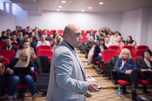 young successful businessman at business conference room with public giving presentations. Audience at the conference hall. Entrepreneurship club