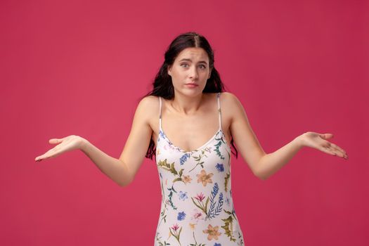 Beautiful, sweet, young girl spreads her arms on the pink background