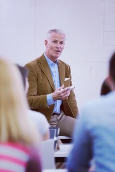 group of students study with professor in modern school classroom